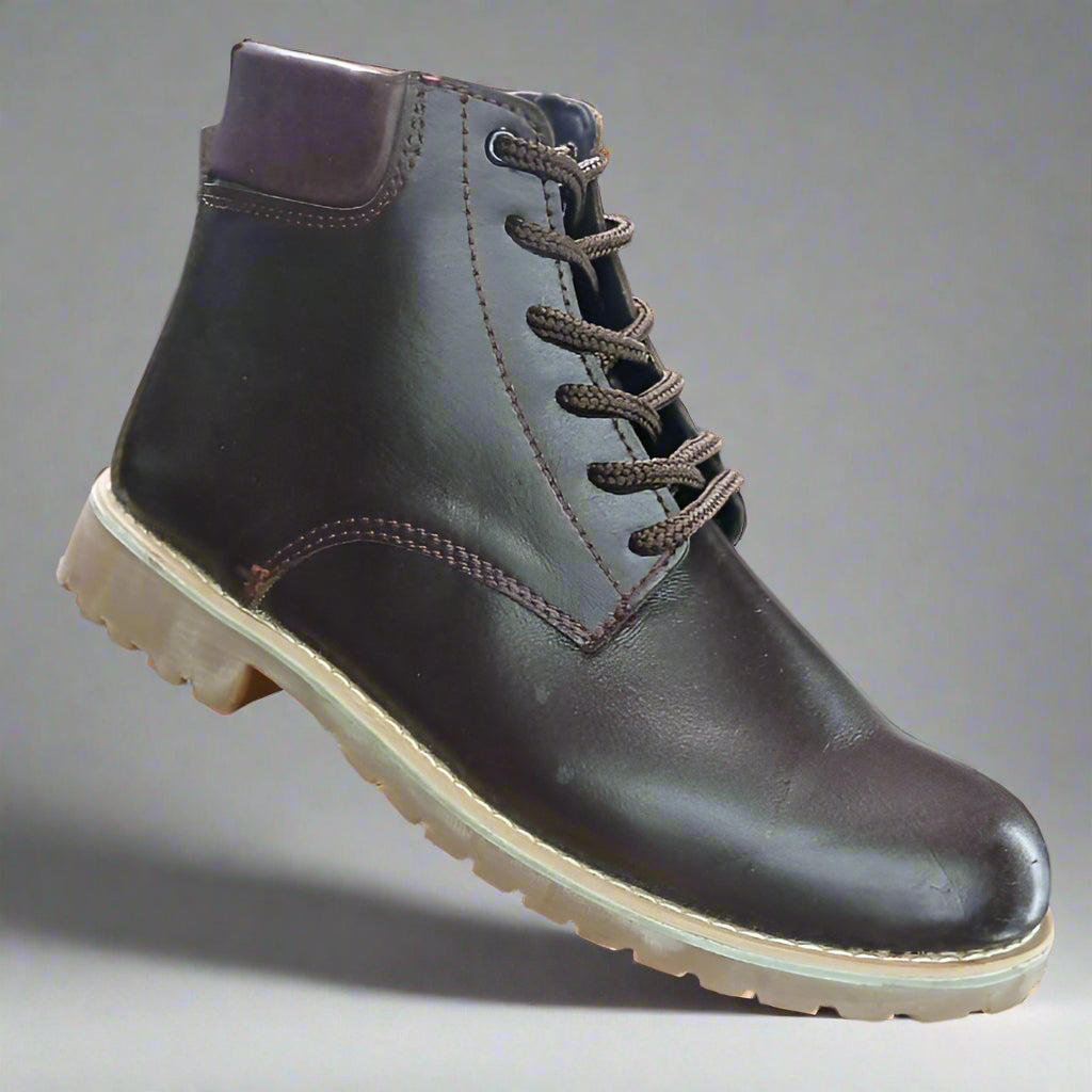 Brown leather boot held by a hand with a blurred background of shoes