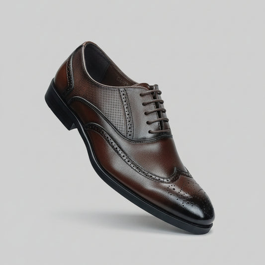 Hand holding a brown leather dress shoe with a blurred background of shoes on shelves.