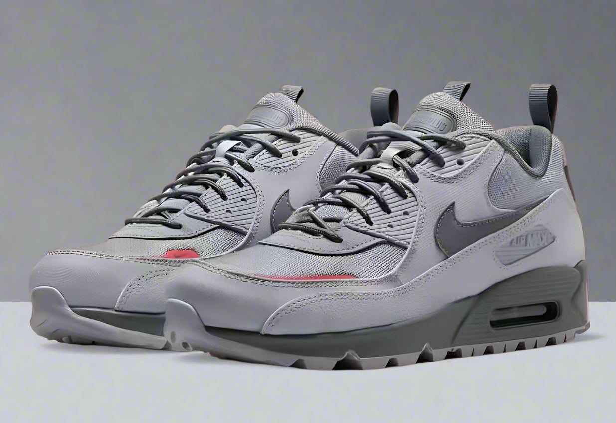 Gray sneakers with a Nike logo on a red background