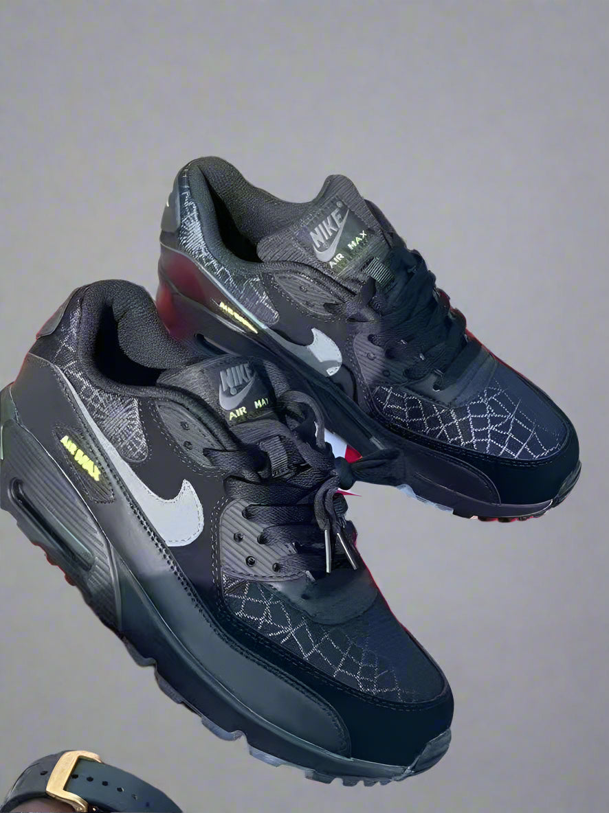 Black Nike sneakers with a red box on a wooden floor