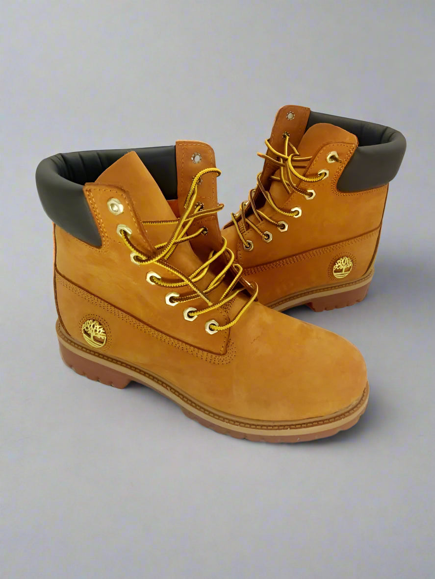 Pair of tan Timberland boots with black soles on a white background