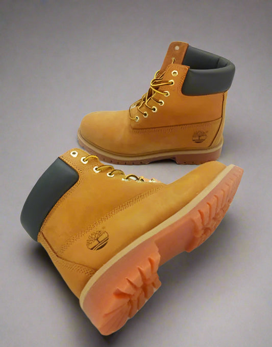 Pair of yellow Timberland boots with black soles on a white background