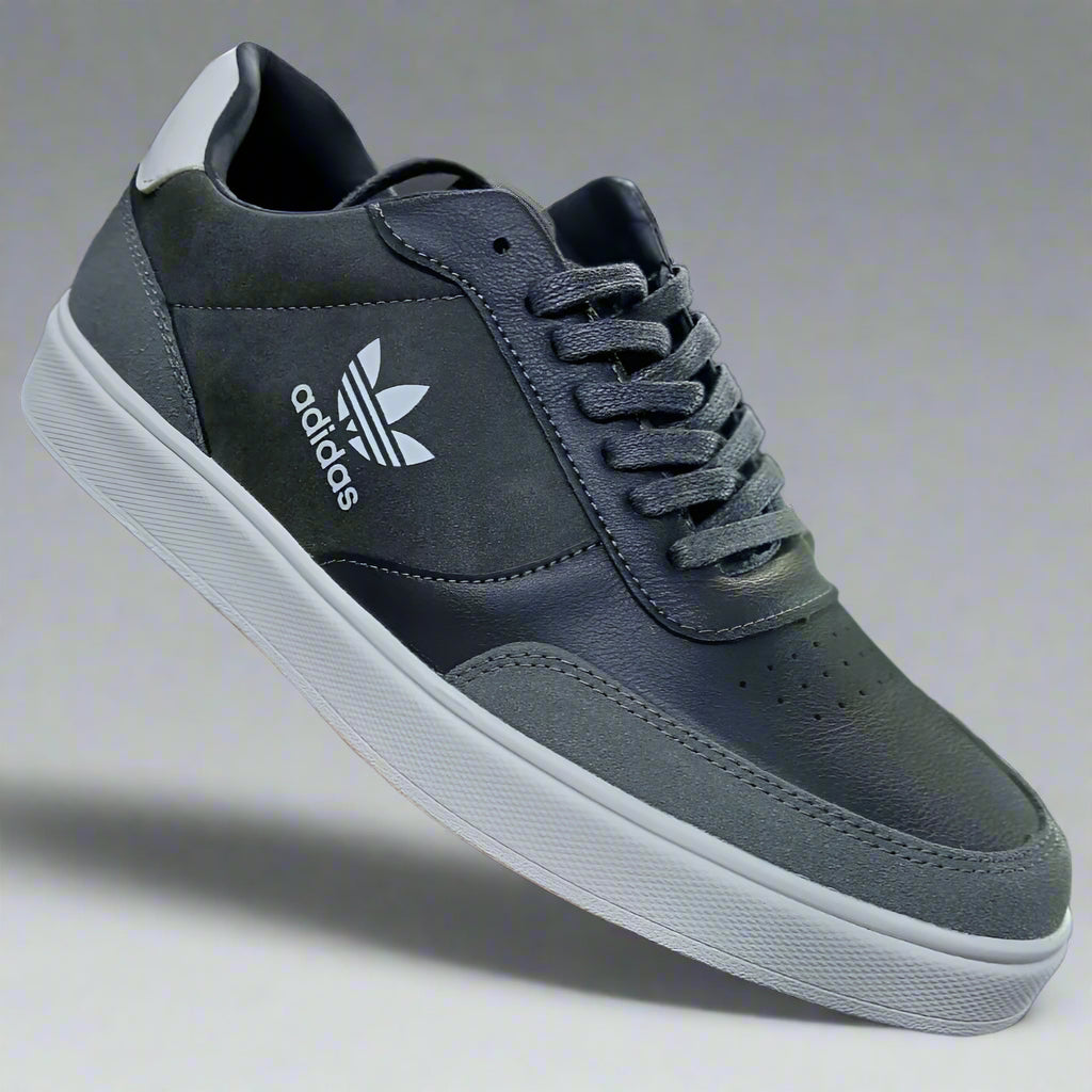 Gray Adidas sneaker held in a hand with a blurred background