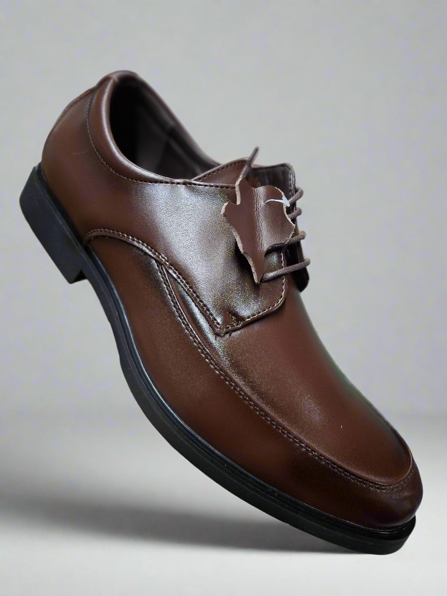 Brown leather shoe with a buckle held by a hand on a tiled floor.