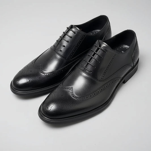 Four black dress shoes on a textured surface