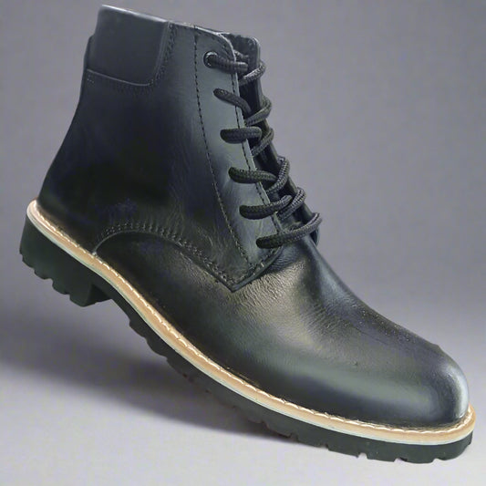 Black leather boot held in a hand with a shoe rack in the background