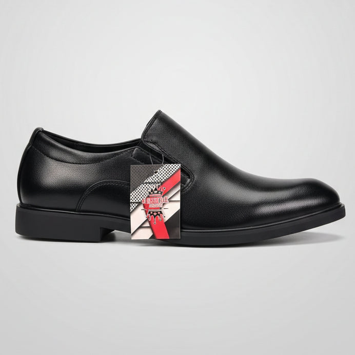 Black slip-on shoe held by a person with a blurred indoor background