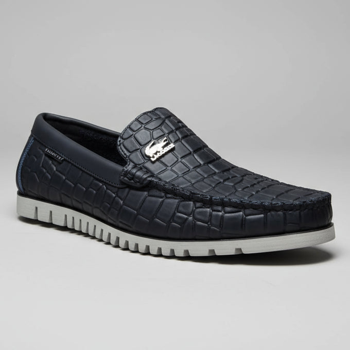 Person holding a black textured shoe with a brand logo against a blurred background