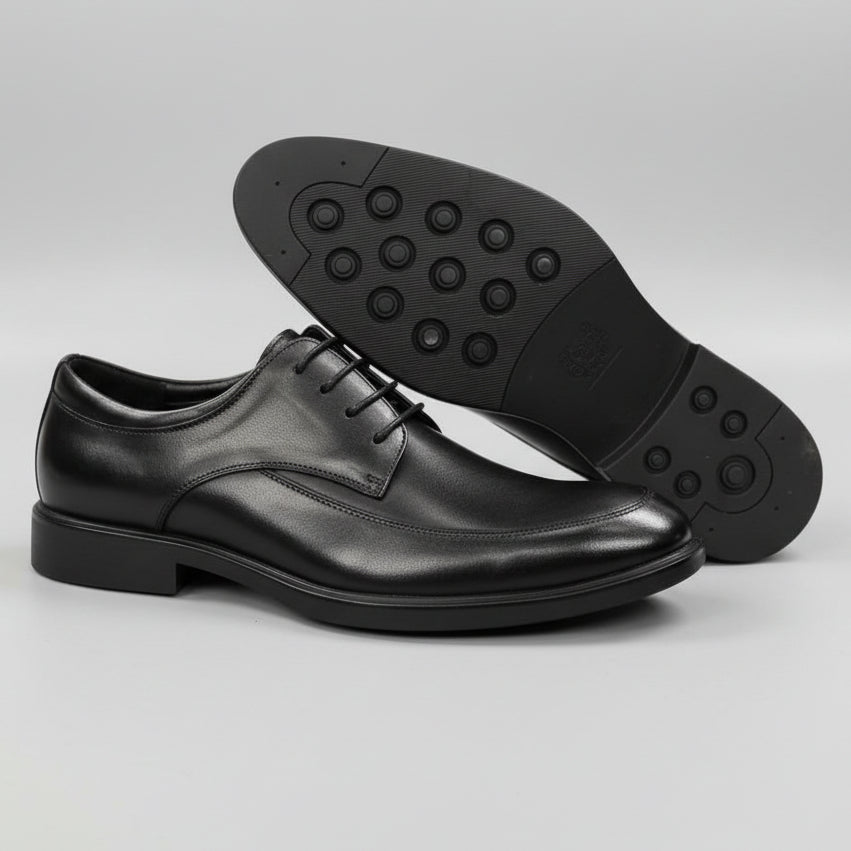 Black dress shoes on a textured surface with a blurred background