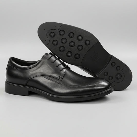 Black dress shoes on a textured surface with a blurred background