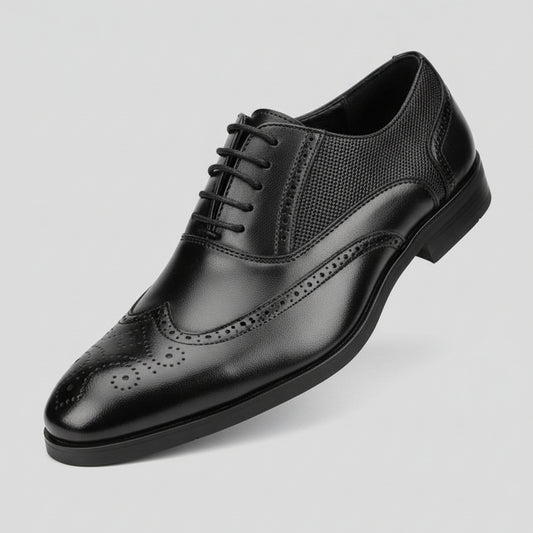 Black dress shoe held in front of a shoe rack with various shoes.