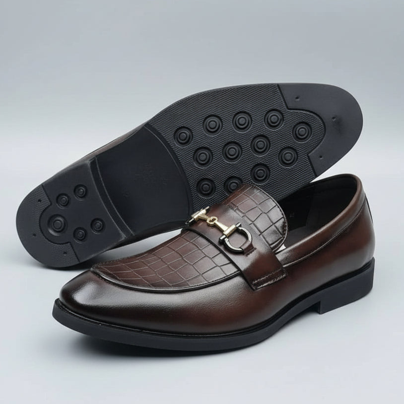 Brown leather shoe with black sole on a textured surface