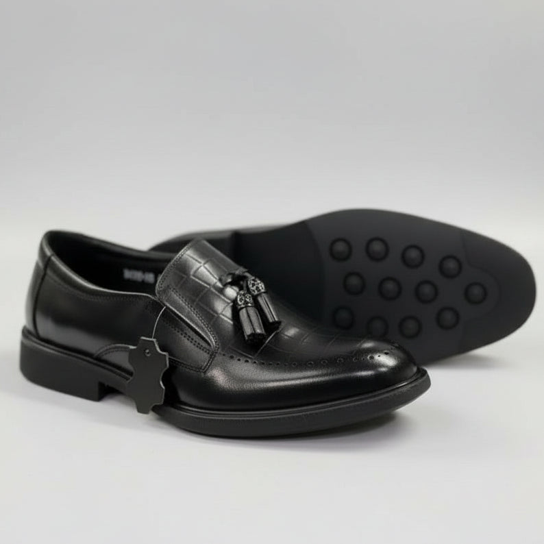 Black dress shoes with tassels on a white surface