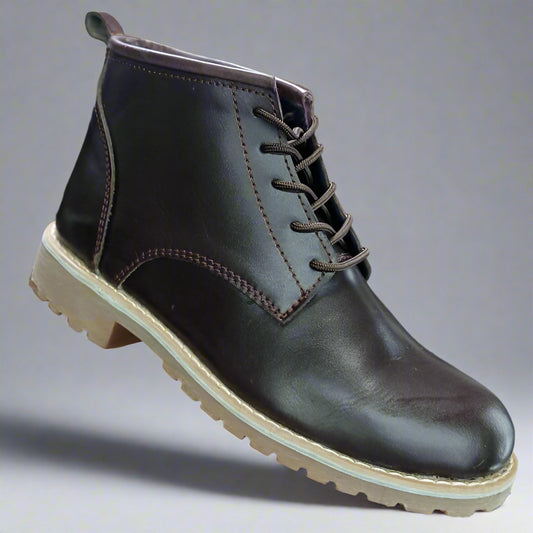 Brown leather boot held in a hand with a blurred background