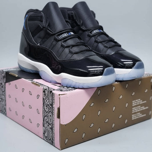Black high-top sneakers held by a person with a box in the background