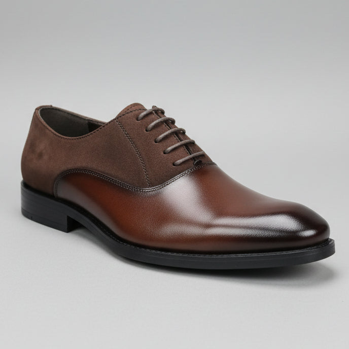 Brown leather shoe held in a hand with blurred background