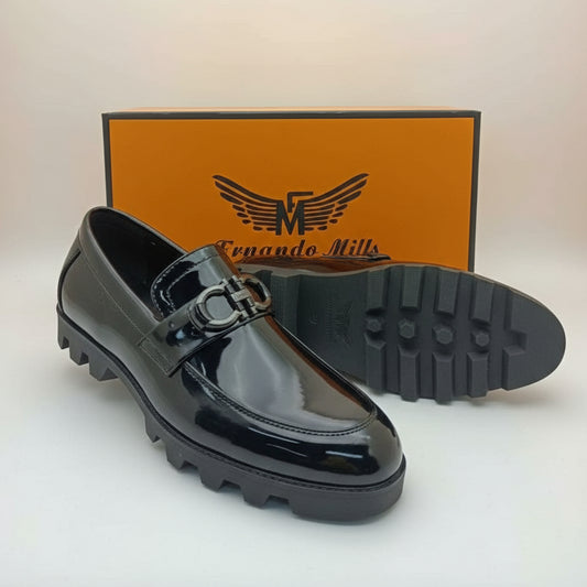 Black shiny loafer shoe with a branded box in the background