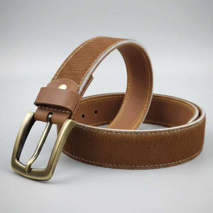 Brown leather belt with a metal buckle on a wooden surface