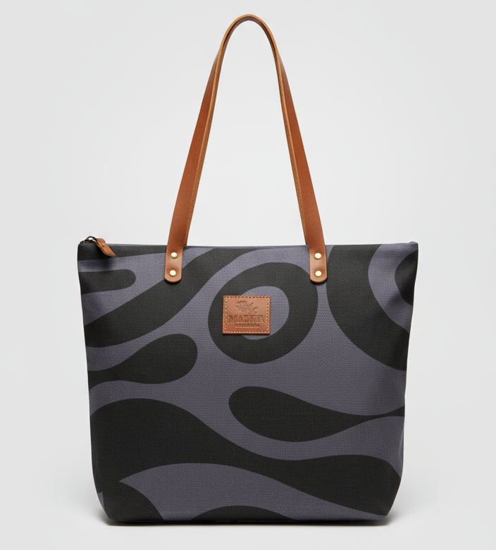 Camouflage-patterned handbag with gold accents on a wooden surface.