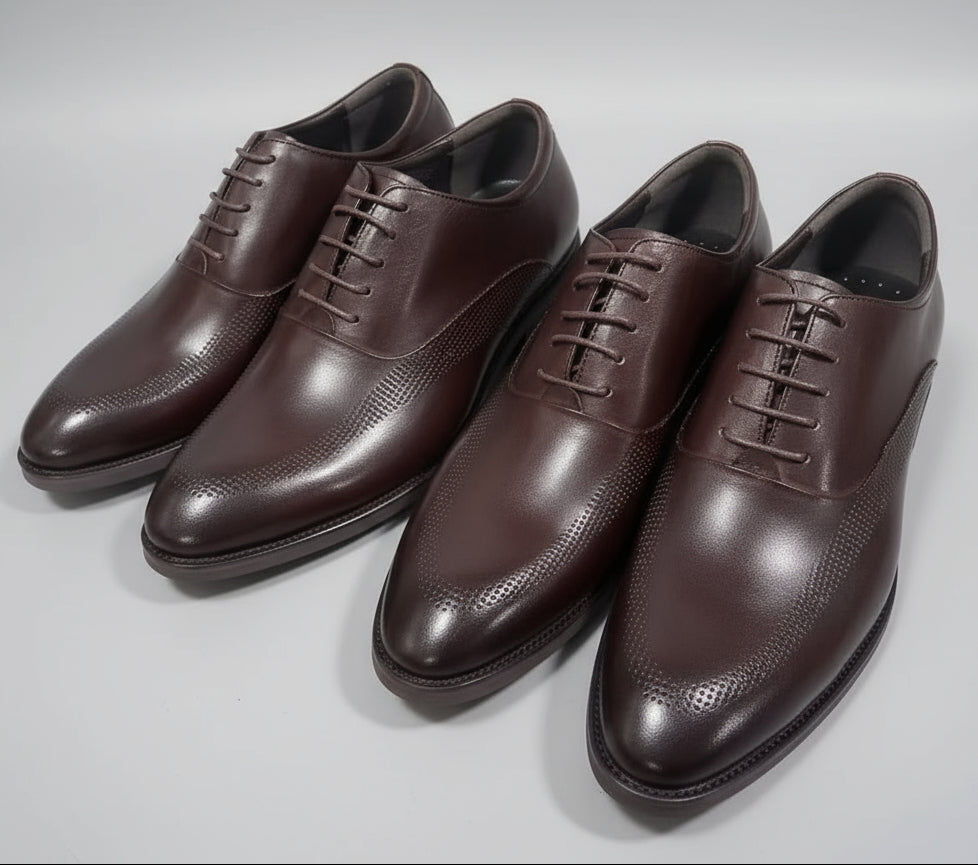 Pair of brown dress shoes on a gray surface