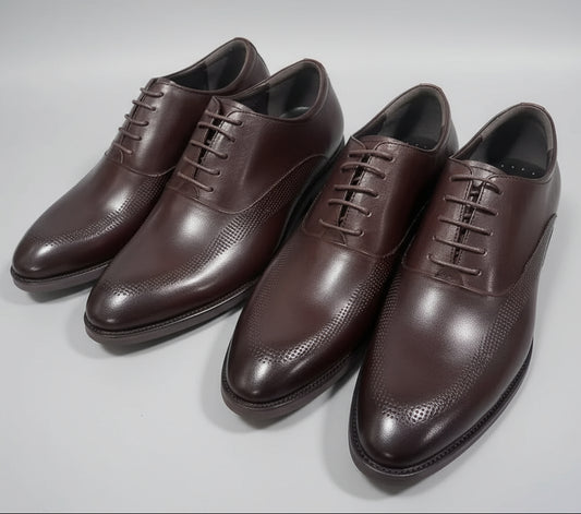 Pair of brown dress shoes on a gray surface