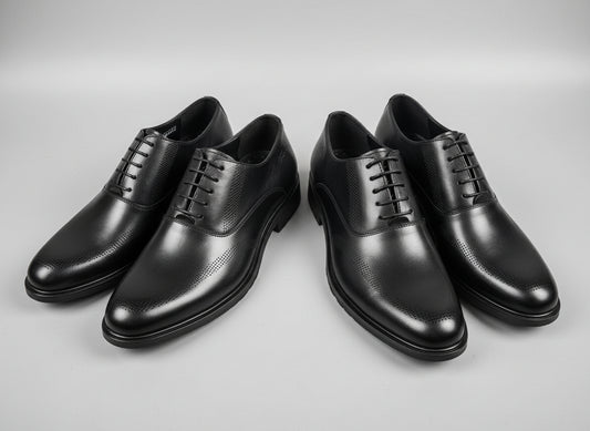 Pair of black dress shoes on a textured surface