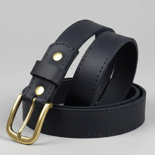 Black leather belt with gold buckle on a wooden surface