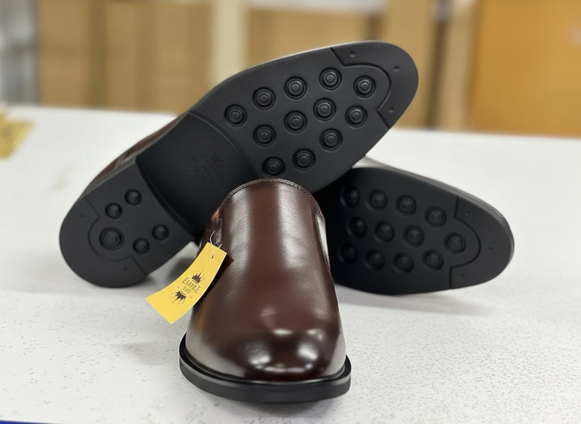 Brown leather shoe with a yellow tag on a white surface