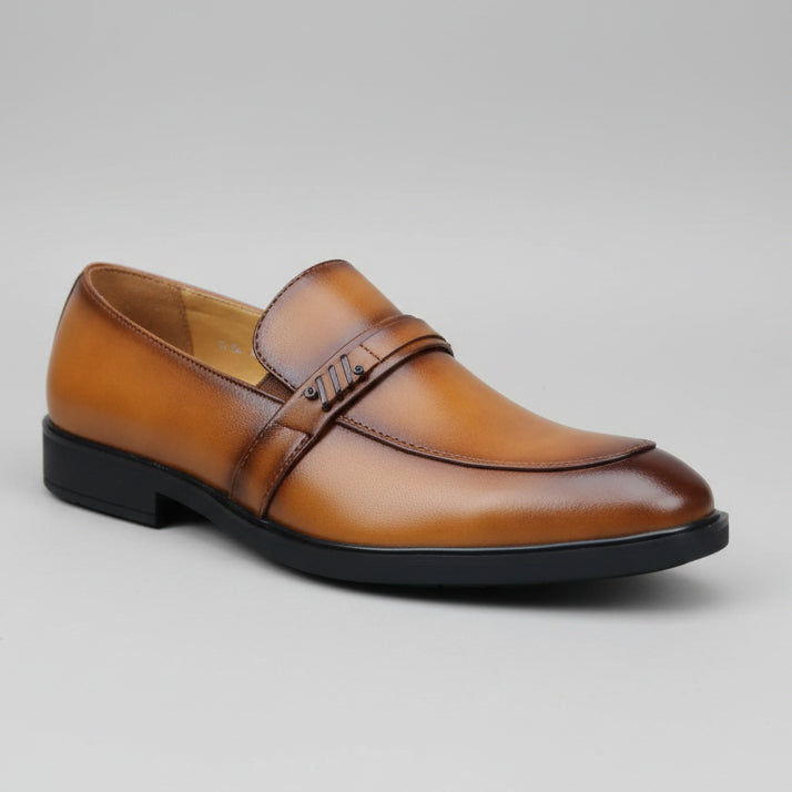 Brown leather shoe held by a hand with a blurred background of a store setting.