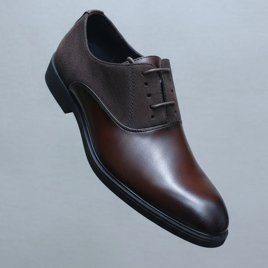 Brown leather shoe held in a hand with shoe shelves in the background