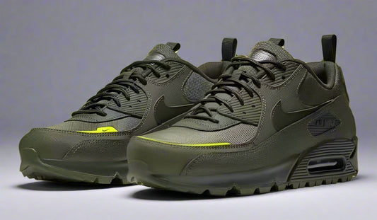 Pair of dark gray sneakers on a bright yellow background
