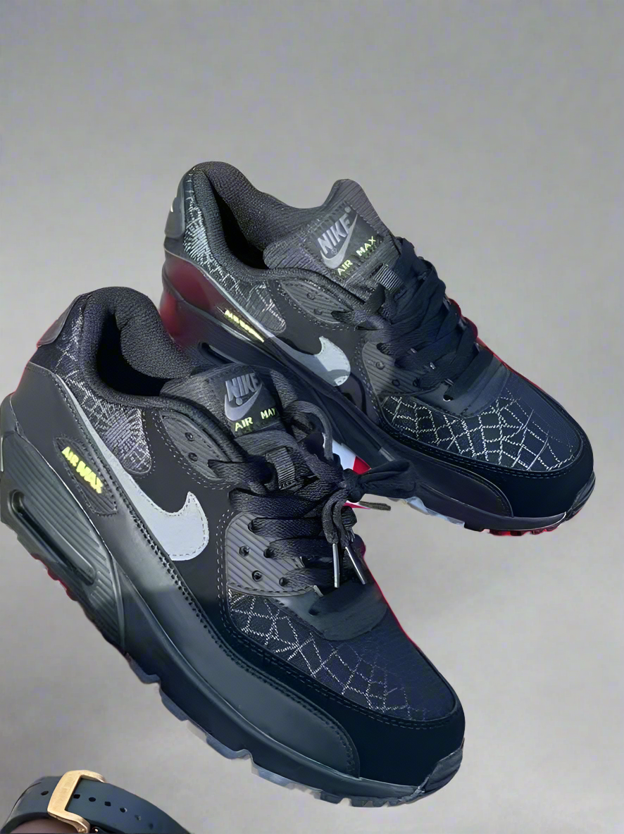 Black and gray Nike sneakers on a wooden floor with a red box in the background.