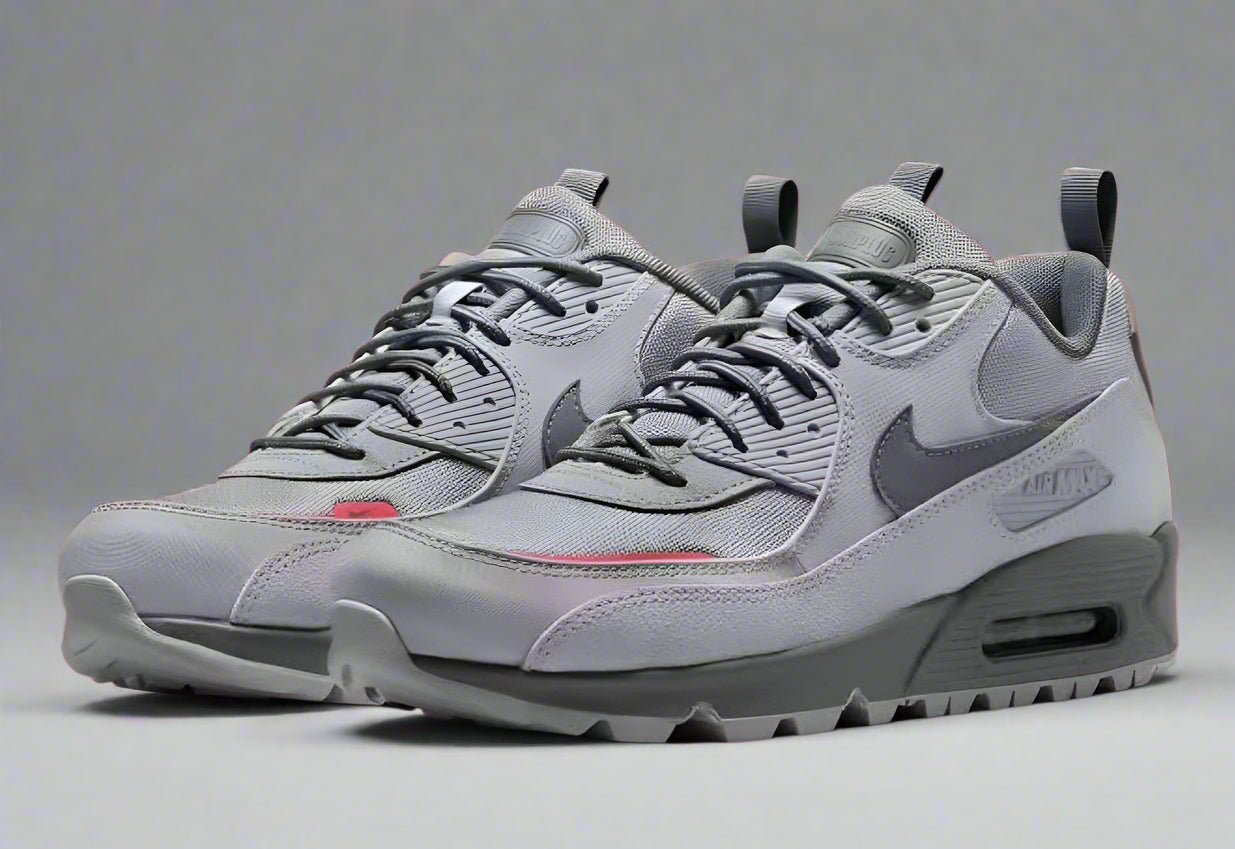 Gray sneakers with a Nike logo on a red background