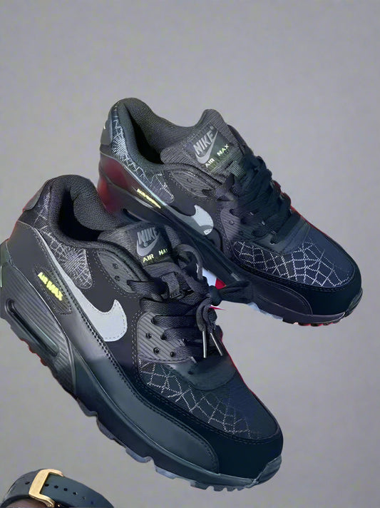 Black Nike sneakers with a red box on a wooden floor