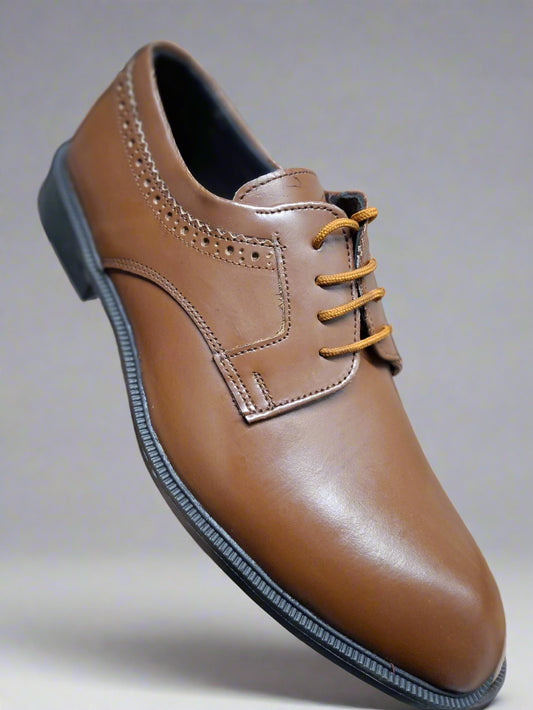 Brown leather shoe with yellow laces held by a hand against a blurred background