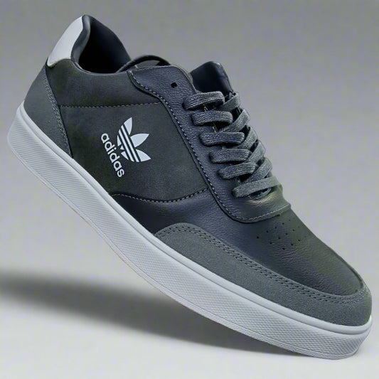 Gray Adidas sneaker held in a hand with a blurred background
