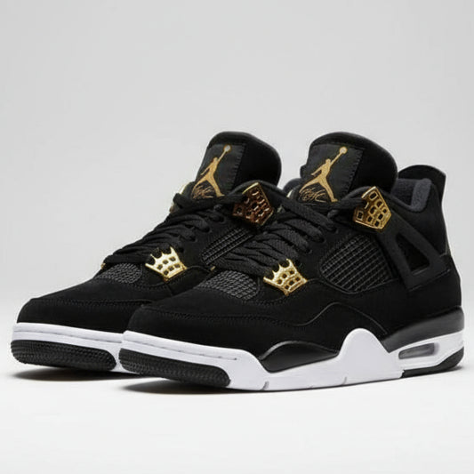 Black high-top sneakers with gold and red accents on a gray surface