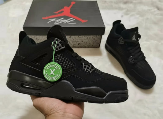 Black sneakers with a green tag held by a hand, Jordan box in the background