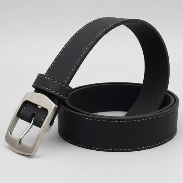 Black leather belt with silver buckle on a wooden surface